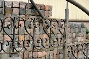a wrought iron fence with a stone wall photo