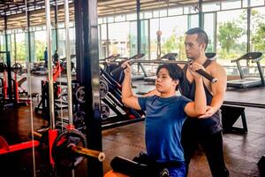 male trainer is planning an exercise program for a client who wants to improve their physical shape in a fitness center photo