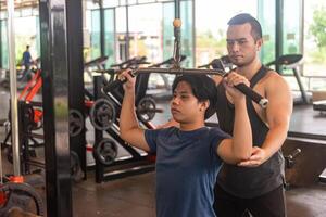 male trainer is planning an exercise program for a client who wants to improve their physical shape in a fitness center photo