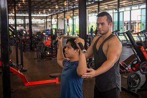 male trainer is planning an exercise program for a client who wants to improve their physical shape in a fitness center photo