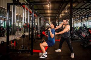 male trainer is planning an exercise program for a client who wants to improve their physical shape in a fitness center photo