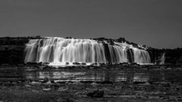 Big waves create beautiful sea views of waterfalls and water flows in Karang Taraje, Sawarna Beach, Indonesia. A favorite location for domestic and foreign photographers to hunt for photos and videos.