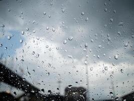 Rain and dew drop on the car glass window during raining. photo