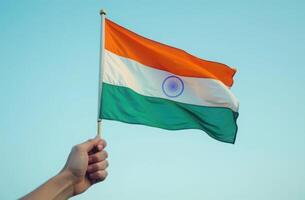 Close-up of a hand holding an Indian flag in his hand on a sky background. Indian Independence Day, Republic of India Day photo
