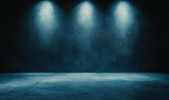 A dark room with a concrete floor and three spotlights shining on the wall. photo