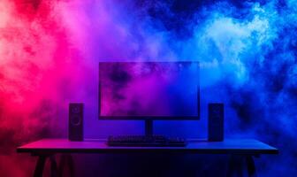 A computer monitor, keyboard, and speakers are set up on a desk, with blue and pink smoke in the background. photo
