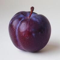 a purple apple with a red stem on a white surface photo