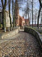 a cobblestone road with a church in the background photo