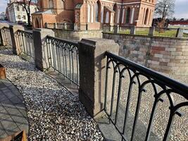 a bench is sitting on a railing next to a church photo