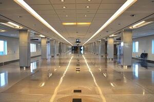 Empty airport terminal corridor with polished floor reflecting light photo