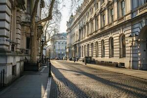 Empty cobblestone street passing through old london england buildings in morning light photo