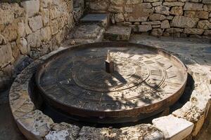 Ancient sundial casting shadow on stone surface in historical place photo