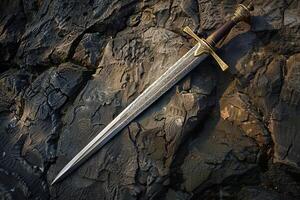 Medieval sword lying on rocks in nature setting photo