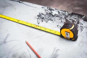 Yellow measuring tape or tape measure on a metal desk for measuring the size of materials , Mechanic tools concept photo