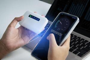 fast internet connection speedtest network bandwidth technology Man using high speed internet with smartphone and laptop computer. 5G quality, speed optimization photo