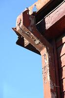 a close up of a red building with a broken window photo