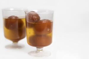 Close-up of delicious Gulab Jamun in transparent glass cups photo