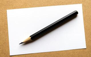A sleek black pencil rests on a crisp white sheet of paper against a textured beige background, providing ample copy space for creative concepts photo