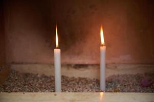 Two lit candles in a serene and quiet setting photo