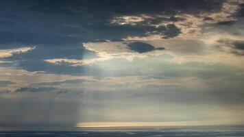 Sunbeams shining through clouds over the ocean video