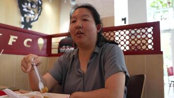 Asian fat woman with a bright face goes about her daily life, eating and walking happily. In the city and in buildings video