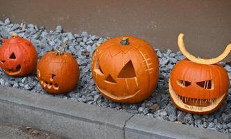 a group of carved pumpkins lined up on a stone wall photo