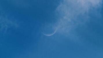 Slice of moon in the day blue sky with clouds video