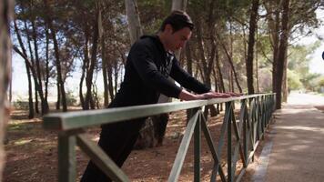 Hand Of A Man Dressed In Black Tracksuit Does Push Up Exercises On The Railing video