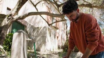 Boy Empties The Pot Of Water Into The Watering Hole In The Countryside video