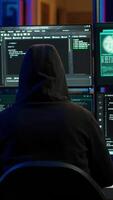 Vertical Malicious man hacking, stealing credit card numbers and manipulating banking systems for own personal gain. Evil hacker running code in apartment on computer monitor, camera A video