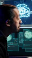 Vertical Hacker using AI machine learning on computer to produce malware corrupting data. Scammer working on PC using artificial intelligence tech, infecting systems, close up shot, camera B video