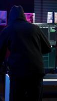 Vertical Hacker arriving in underground HQ, ready to start coding malware designed to exploit network backdoors and bypass security measures such as logins and password protections, camera B video