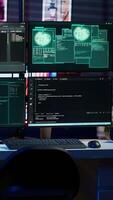 Vertical Panning shot of high tech computer system running malicious code in empty apartment. PC monitors in empty neon lit criminal hideout used by hackers to commit illegal activities video