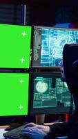 Vertical Cybercriminal using AI deep learning to produce virus corrupting data on mockup PC. Rogue developer working on isolated screen computer using artificial intelligence, penetrating security, camera B video