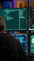 Vertical Hacker drinking coffee while running artificial intelligence spyware software designed to gather information from users. Script kiddie doing illegal stuff using AI, consuming beverage, camera A video
