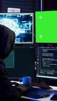 vertical hacker usando verde tela pc e ai para encontrar sem patch conexões e roubar dados. scammer usando artificial inteligência e croma chave computador para compromisso digital dispositivos, Câmera b video