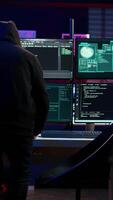 Vertical Hacker arriving in secret base with laptop, ready to start programming viruses. Scammer in criminal den opening notebook to exploit network servers and bypass security measures, camera B video