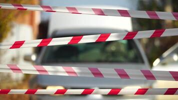 Red and white warning tape swinging in the wind. Protection sign. Don't cross the line. Red White caution tape pole fencing is protects for No entry. Backdrop without people, empty street. video