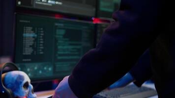 Hooded script kiddie taking laptop out of suitcase, prepared to launch DDoS attack. Close up shot of scammer at computer desk getting notebook from bag, starting work on malware script, camera B video
