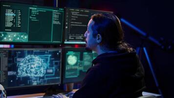 Hacker drinking coffee while running artificial intelligence spyware software designed to gather information from users. Script kiddie doing illegal stuff using AI, consuming beverage, camera B video