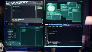 Lines of code running on computer monitors in empty room used by cybercriminal stealing sensitive information. Dangerous scripts on PC used for threatening network systems, panning shot video