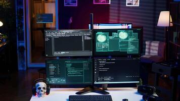 Panning shot of high tech computer system running malicious code in empty apartment. PC monitors in empty neon lit criminal hideout used by hackers to commit illegal activities video