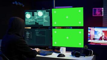 Cybercriminal using isolated screen PC in apartment hideout getting hacking attacks rejected by security. Hacker using chroma key computer monitor seeing access denied error message, camera B video