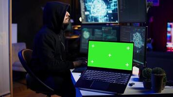 Isolated screen laptop used by cybercriminal in underground hideout to write lines of code and malware scripts. Mockup notebook used by evil programmer in hidden bunker, close up shot, camera B video