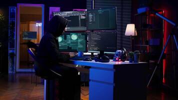 Hacker stealing credit card numbers while listening music through headphones. Evil developer programming in apartment, infiltrating banking systems, hearing songs, camera B video