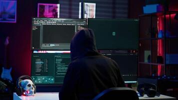 Cybercriminal fraudulently breaching security systems while hiding in secret HQ. Hacker breaking down security systems defenses using rogue scripts to steal valuable data, camera A video
