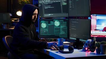 Hacker stealing credit card numbers while listening music through headphones. Evil developer programming in apartment, infiltrating banking systems, hearing songs, camera A video