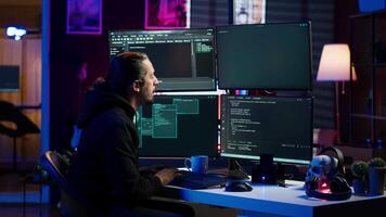 Hacker in secret hideout typing on keyboard, trying to hide online activity after stealing data. Scammer attacking victims computers using malware while trying to avoid being detected, camera A video