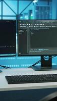 Vertical Lines of code running on computer screens in data center, used for troubleshooting rackmounts in server rows. Close up shot of script working on PC monitors upgrading hardware video