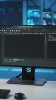 Vertical Lines of code running on computer screens in data center, used for troubleshooting rackmounts in server rows. Close up shot of script working on PC monitors upgrading hardware video
